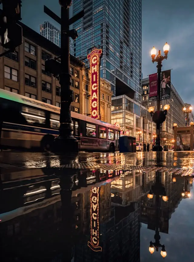 The Chicago Theatre sign on State Street reflected in a rain puddle